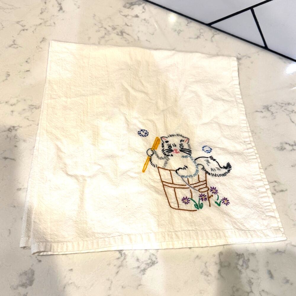 vintage handmade dish towel featuring embroidered cat in a bucket with bubbles